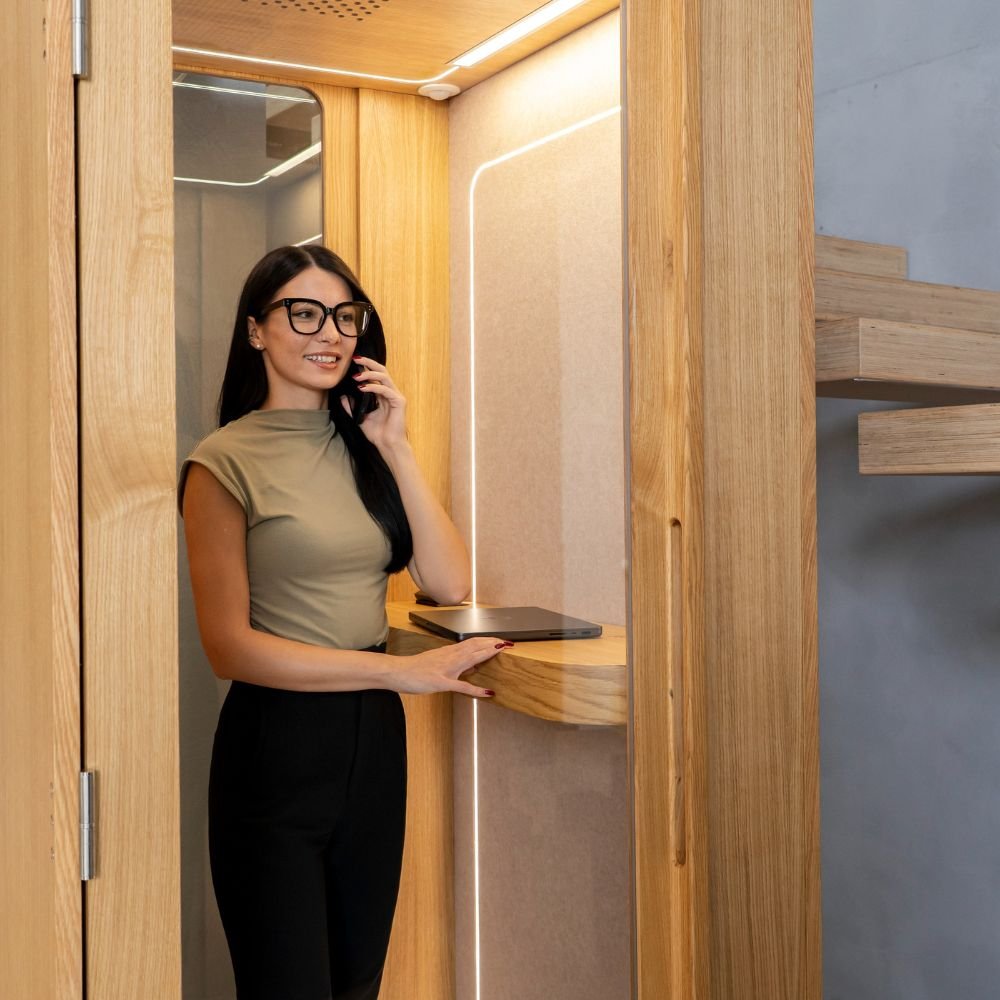 Cabine acoustique en bois 1 place Haven — utilisee pendant un appel telephonique